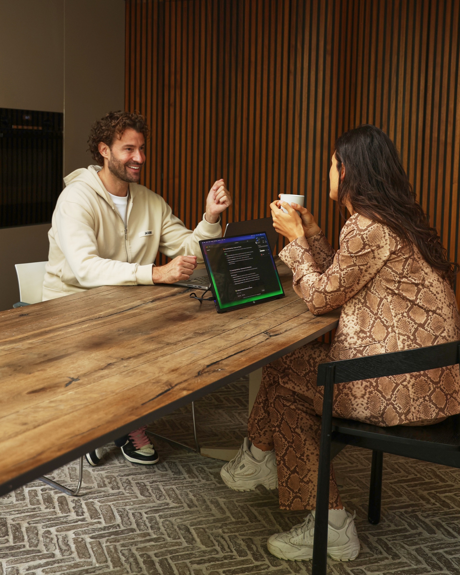 Twee professionals in gesprek met een Screenmate-scherm op tafel